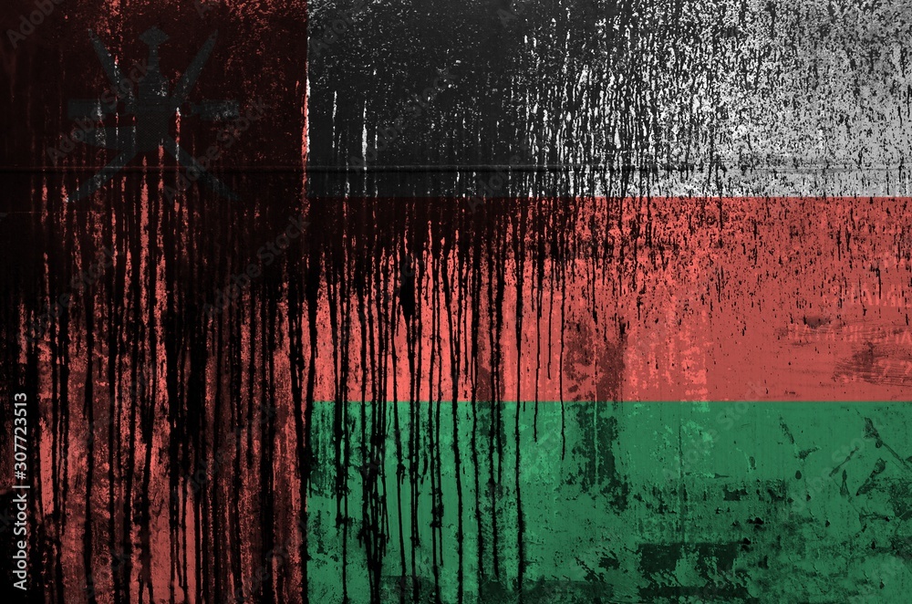 Wall mural Oman flag depicted in paint colors on old and dirty oil barrel wall closeup. Textured banner on rough background