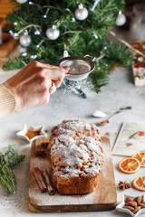 Fototapeta na wymiar Stollen is fruit bread of nuts, spices, dried or candied fruit, coated with powdered sugar. It is traditional German bread eaten during the Christmas season. New year prep.