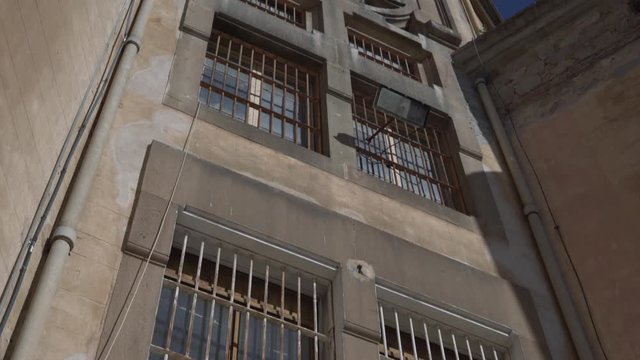 facade of the prison building with spotlight on wall and bars on windows
