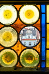 Panorama of Krakow's Old Town through the colorful stained glass window of the Town Hall Tower. In transparent Circle - tenement house "Kamienica Pod Jagniemi"