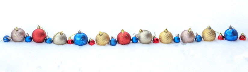 Coloted christmas balls in row isolated on snow, banner