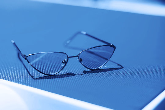 Fashion sunglasses on sunbed in blue color.