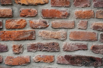 Fototapeta premium Fragment of the restoration of masonry of old red brick. different size and color bricks, background, screensaver place for text, copyspace.