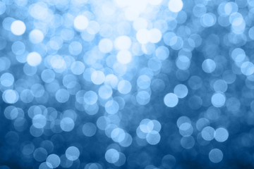 Abstract composition. Blurred photo of glitter with beautiful bokeh in classic blue, color of the year 2020. Defocused light.