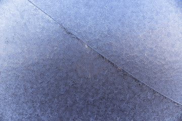 Frost on the window. Beautiful frosty pattern on the cracked window. Patterned snow on the broken glass. Winter frost wallpaper