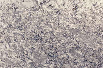 Texture of snow-white snowflakes on transparent glass. Beautiful frosty pattern on the window. Winter wallpaper frosty snowflakes on the glass.