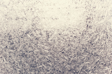 Texture of snow-white snowflakes on transparent glass. Beautiful frosty pattern on the window. Winter wallpaper frosty snowflakes on the glass.