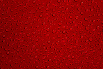 Homogeneous wet with water drops dark red background with even pattern, closeup, details