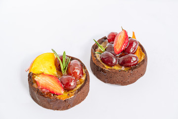 Two tasty colorful cakes with icing fruits and berries on white background, isolated and close up