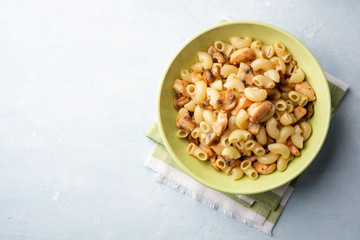 Pasta with chicken, mushrooms and parmesan cheese on concrete background. Top view, copy space.