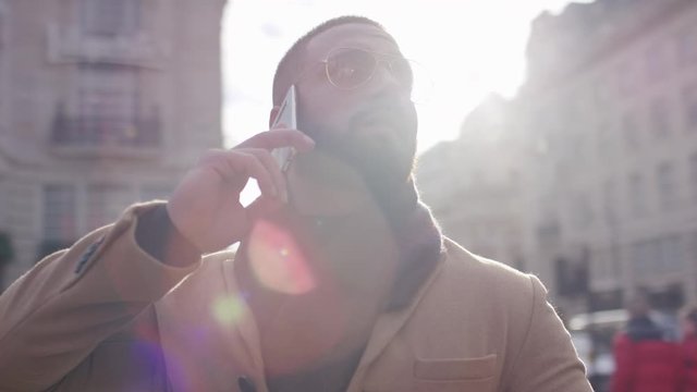 Camera circles a man on his phone in the city, in slow motion 