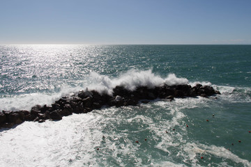 Seascape with horizon line over sea and wave is crashing stones.
