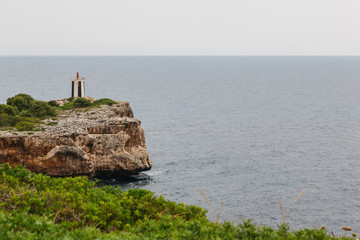 faro de puerto de Manacor, en  la isla Mallorca, al pie de un acantilado.