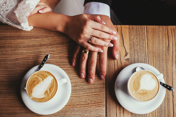 young couple in love sitting in a cafe in a cozy atmosphere holding hands