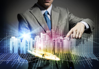 Businessman touching colorful hologram of city