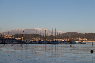 Boats in the seaport at sunset with mountains on background, La Spezia, Liguria, Italy.