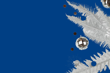 Christmas composition with silver tree branches, christmas ball, snowflakes on blue background
