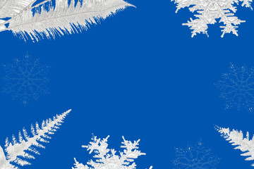 Christmas or winter composition. snowflakes and silver tree branches on blue background.
