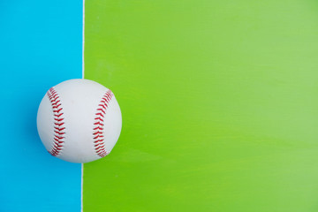 Baseball ball isolated on bright blue and green background with copy space for sports concept .
