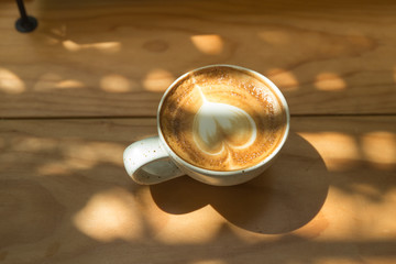 Cup of coffee latte on Wooden Table under with Natural Light , Top View.