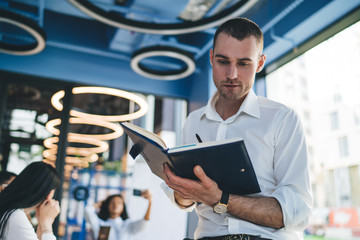 Attentive worker writing in copybook in office