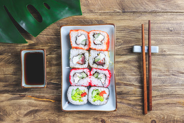 japanese sushi food. Rolls with tuna, salmon, shrimp, crab and vegetables. Top view of assorted sushi. Rainbow sushi roll on wooden bsckground. Flat lay