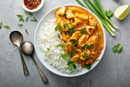 Chicken and cashew red curry with rice and herbs, thai inspired dish overhead view