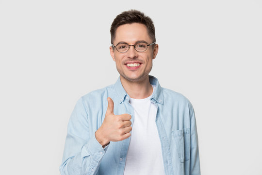Head shot of smiling handsome man holding thumb up