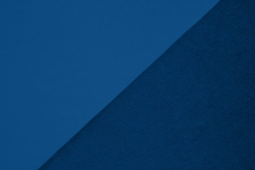 Textured and plain paper sheets divided diagonalliy creating line partition. Classic blue colored...