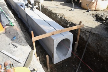 Installation construction of street gutter on the road.