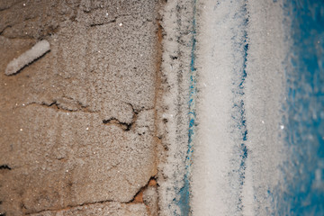 Rime and frost on the wall. Small pieces of ice. Cold in the room.