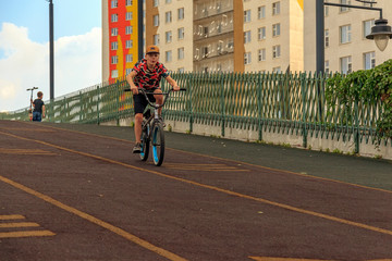 boy descends from a hill on a BMX bike. Velodrome in the courtyard of the residential complex....