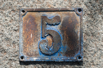 Old retro weathered cast iron plate with number 5 closeup