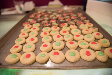 Sheet pan of round christmas cookies with red and green icing