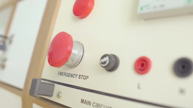 Engineer hand immediately press on red emergency button to stop machine engine on electric generator interface in factory central control room, safety concept