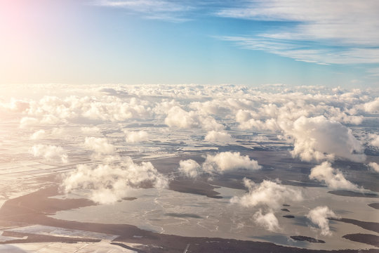 Aerial panoramic landscape view of earth with frozen lake and field. Cloudscape skyline photo from plane landing in austrian airport. Blue sky on background. Sunset or sunrise time