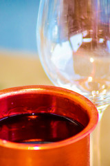Wine in red iron mugs and glass