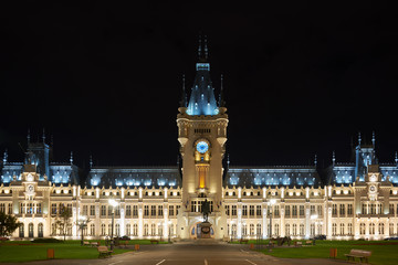 Clock tower of the Palace of Culture in Iasi, Romania. Evening illumination of the palace, cityscape. The building combines several architectural styles: neo-Gothic, romantic and neo-baroque.