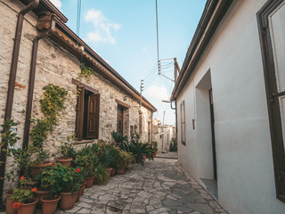 Fototapeta na wymiar Beautiful narrow street of Pano Lefkara village, Cyprus with flower pots and masonry.