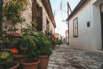 Beautiful narrow street of Pano Lefkara village, Cyprus with flower pots and masonry.