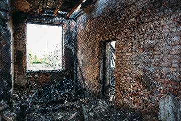 Burned house interior after fire, ruined building room inside, disaster or war aftermath concept.