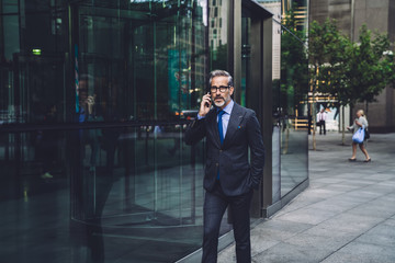 Successful businessman walking and talking on phone