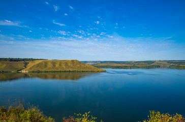 summer time landscape photography of hill land view to horizon shore line district of lake peaceful waters 