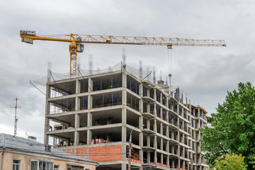Construction of multi-storey monolithic house and industrial building crane isolated on white background. Concept of construction