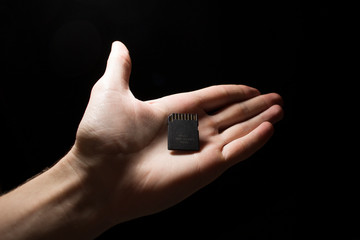SD card in hand on a dark background