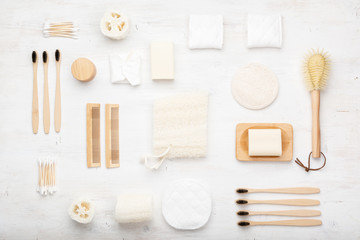 Fototapeta na wymiar Zero waste with natural biodegradable accessories. Bamboo toothbrushes, handmade packaging free soap shampoo bars, cotton buds pads, hygiene products loofah on white, top view, selective focus
