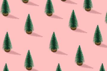 Winter Composition made with christmas trees on pastel pink background.