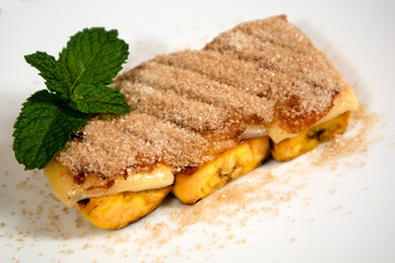 Brazilian dessert Cartola on white background. Made with fried bananas, cheese and suggar with...