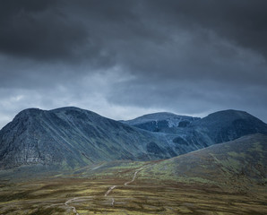 Autumn in Rondane National Park, mountain range and dark, cloudy sky, Norway.