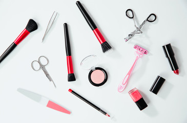 Top view on set of woman make up cosmetics on white background. Beauty and fashion concept. On table lies lipstick, eye pencil, eye shadow, brushes. Fashionable Women's Cosmetics and Accessories.
